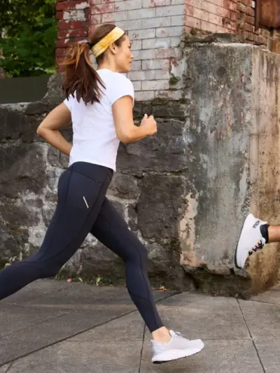 Man and woman running in HOKA running shoes