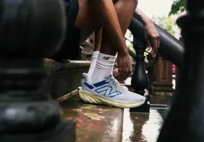 Man tying the laces of New Balance running shoes