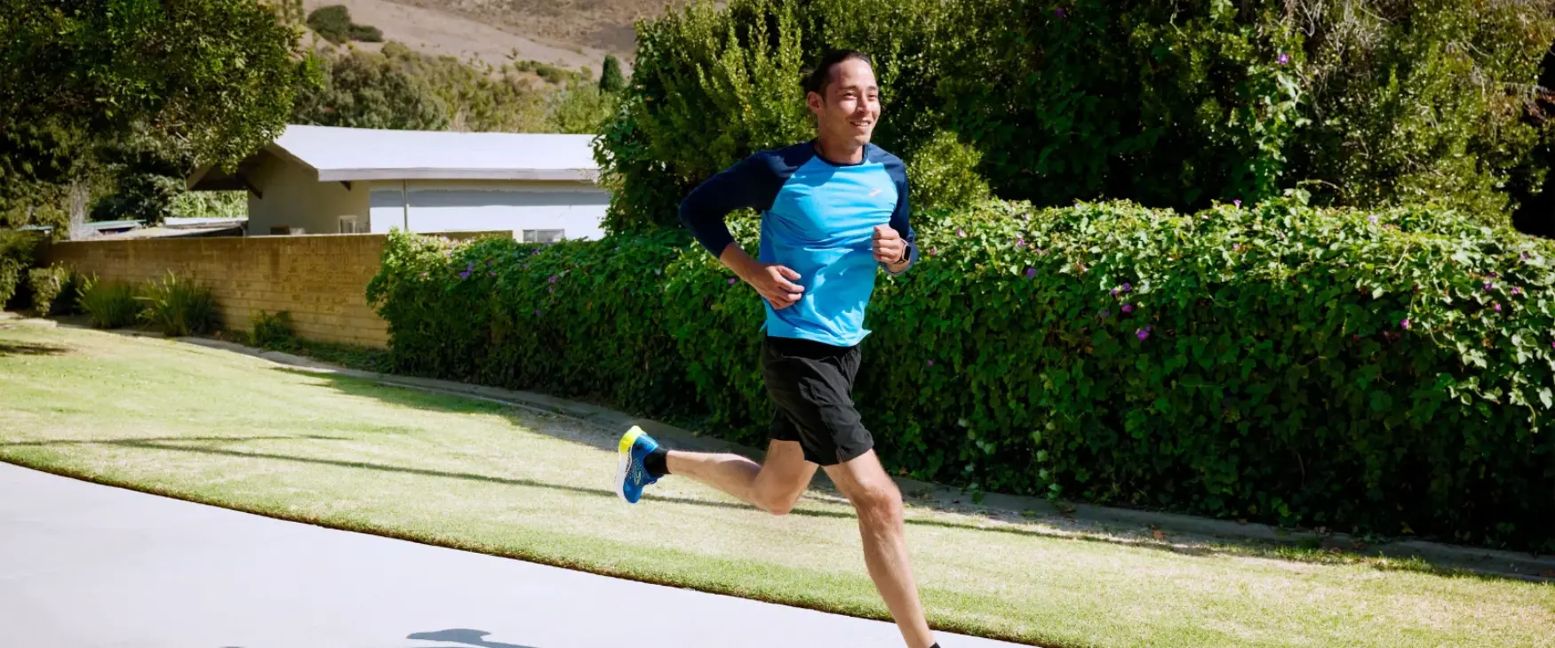 Man running down a path in a pair of Brooks running shoes
