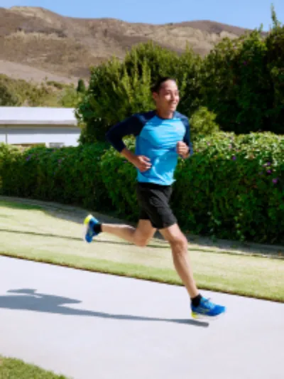 Man running down a path in a pair of Brooks running shoes thumbnail