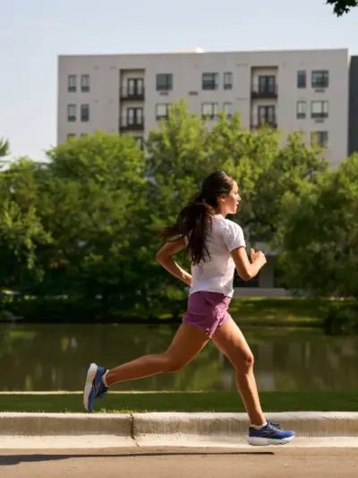 Woman running down a sidewalk in Brooks running shoes