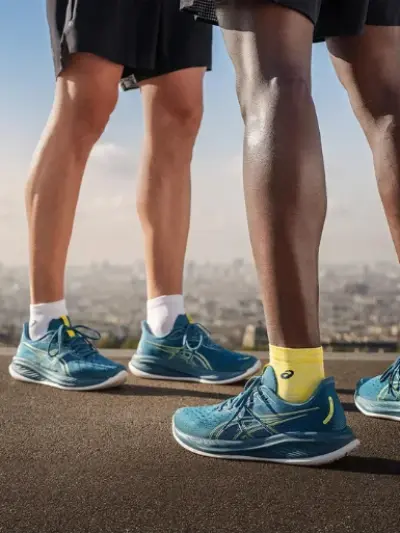 Close up shot of two people wearing a pair of Asics Gel-Cumulus running shoes