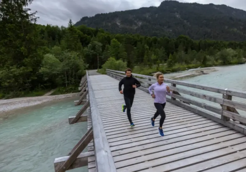 Man and woman running in a pair of Brooks running shoes