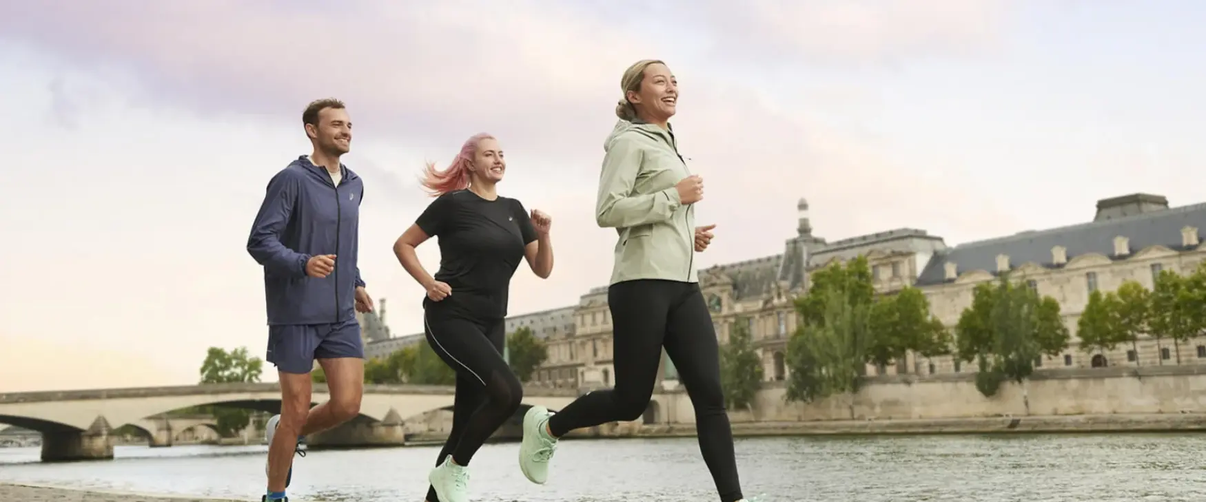 Group of a man and two women running in Asics running shoes