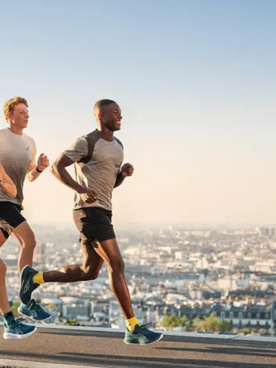 Group of two men and a woman running in Asics running shoes