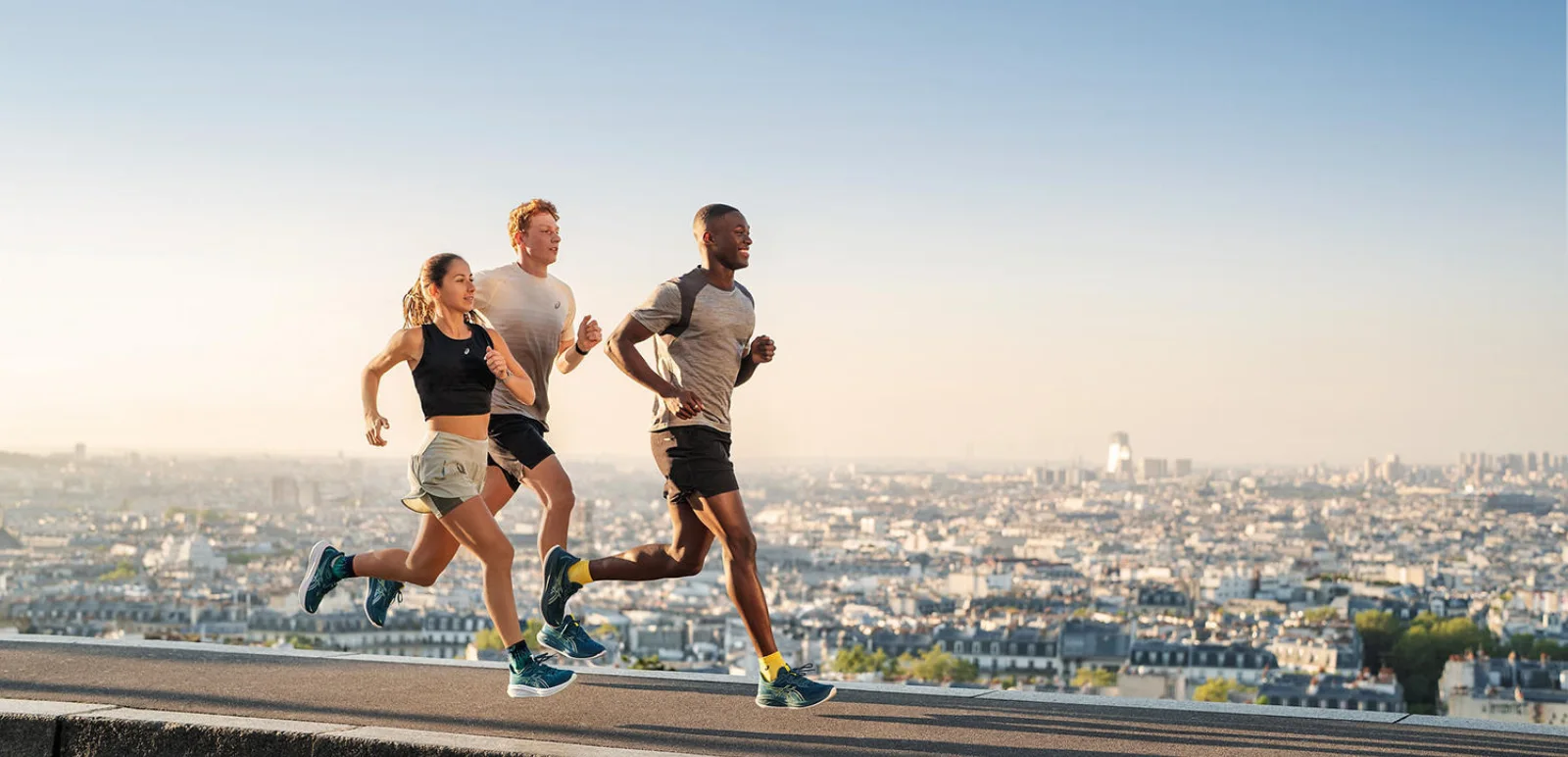 Group of two men and a woman running in Asics running shoes