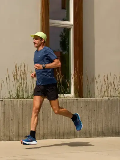 Man running on a sidewalk in a pair of Brooks running shoes
