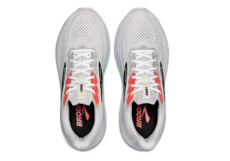 Top view of a pair of Brooks Ghost 17 running shoes in white with red and black accents, showing the mesh upper and branded insoles.