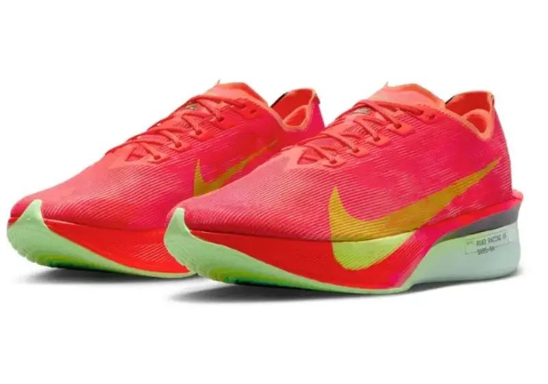 Angled front view of a pair of Nike Vaporfly 4 running shoes in a bright crimson and lime green colorway, with large gradient yellow swooshes and aerodynamic design.