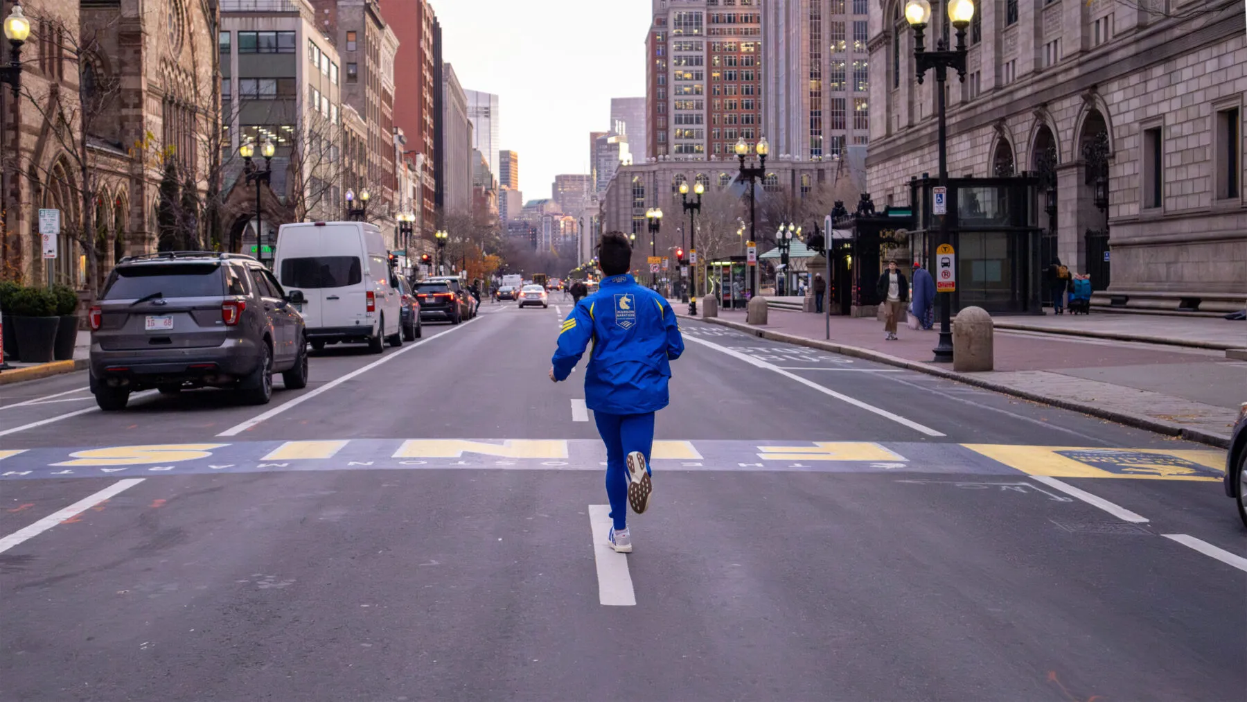 runner crossing boston marathon finish line in adidas baa jacket