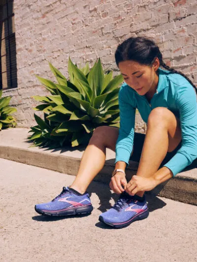 Woman tying brooks ghost 15